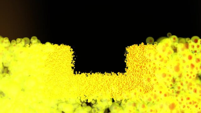 Bright yellow and orange bubble particles filling a U shaped form against black, warm abstract motion background with soft blurred foreground and copy space