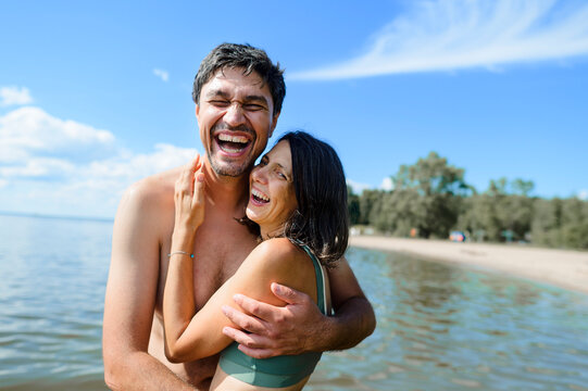 A happy man and woman hug each other in the sea during vacation