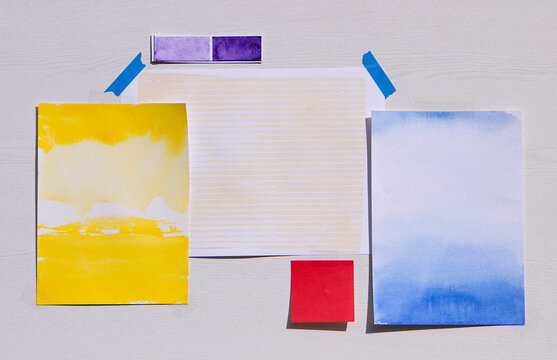 Abstract watercolor paper collage taped to a wall with copy space