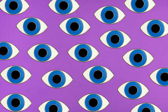 A colorful pop art pattern of blue eyes covers a purple background