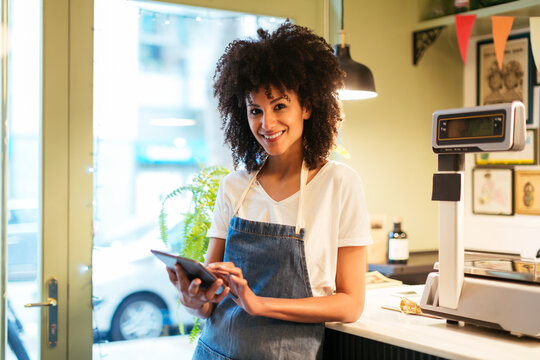 Portrait of smiling woman with tablet in a store