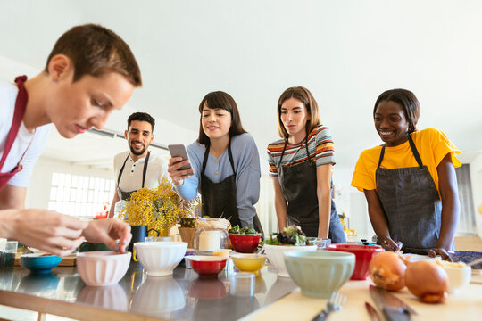 Friends in a cooking workshop watching instructor