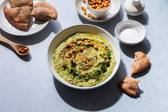 Top view of homemade vegan green wild garlic hummus with flatbread