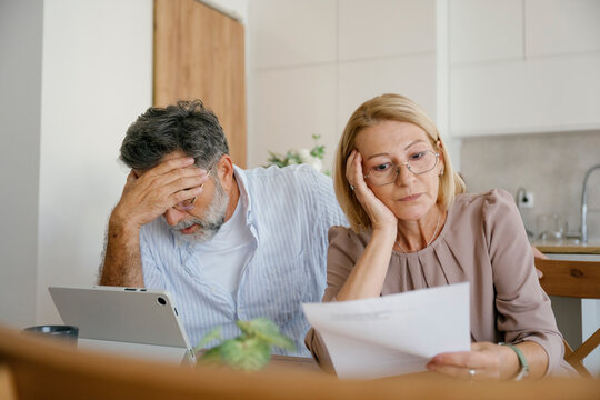 Couple discussing bills and finances at home in a worried mood