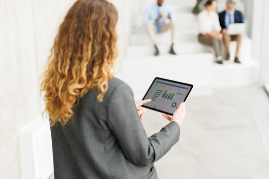 Businesswoman analyzes growth chart on digital tablet in the office