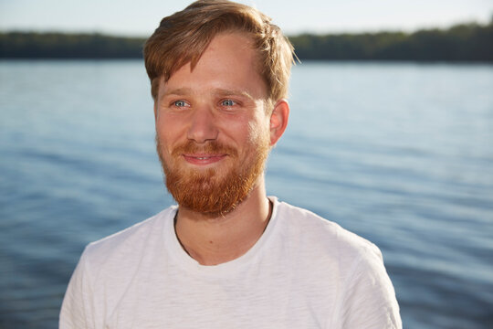 Smiling young man at a lake