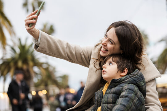 Mother and toddler son take a selfie with a smartphone outdoors