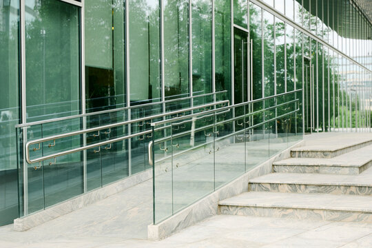 Modern building exterior features a glass wheelchair ramp