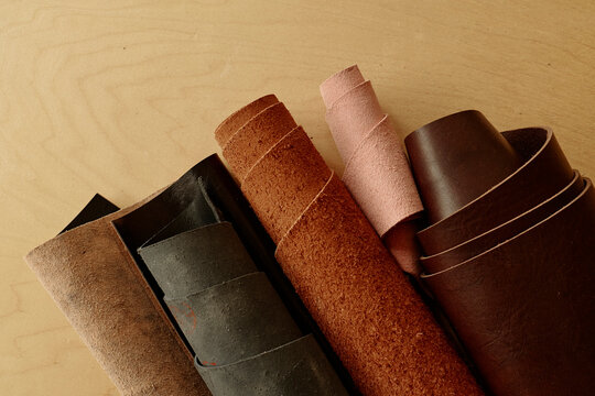 Rolls of genuine leather materials on a wooden table