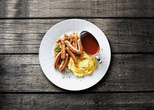 Traditional German bratwurst is served with sauerkraut and potato