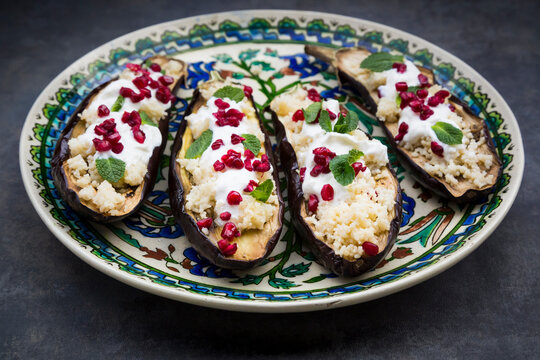 Filled aubergine, couscous, yogurt sauce, mint and pomegranate seeds