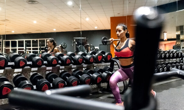 Woman lifting barbell in gym