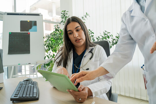 Female doctor discusses healthcare prevention on tablet with mentor