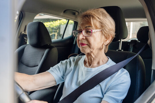 Senior woman driving an eco car on the road