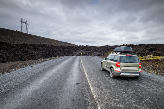 Car parked on Route 43 blocked by fresh basalt lava flow in Iceland