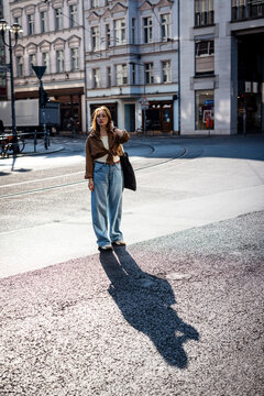 A woman casts a shadow on a city street in Berlin