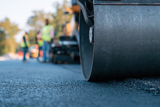 Close up road roller compacting fresh asphalt for construction site background and infrastructure project banner