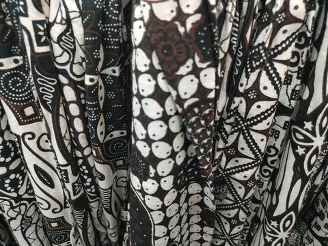 Close up of traditional Indonesian batik patterned fabric textile with brown, black and white ethnic design. Concept of cultural fashion apparel, heritage clothing, and textile