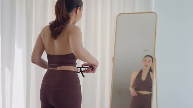 Rear view people young adult asian woman self caliper measure waist size shape lean body mass index fat track weight loss perimenopause life anti aging diet preventive modern medicine asia health care