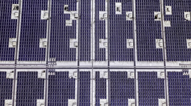 Aerial view of solar panel layout array on a flat industrial rooftop in Los Angeles, California, United States.