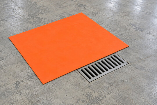 Flexible drain cover partly lifted over a floor drain grate