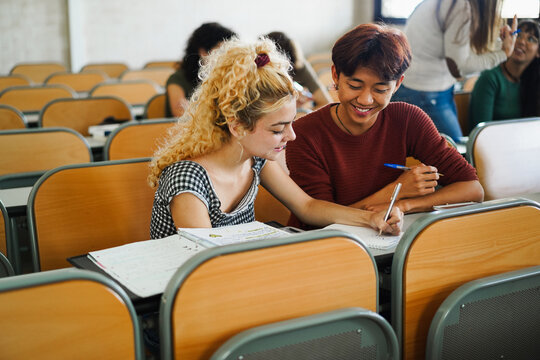 Students writing a theme inside university class room - Back to school and campus lifestyle concept - Main focus on asian boy face - UGC content