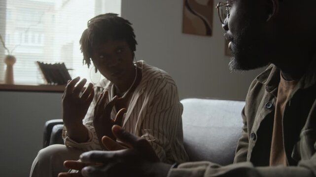 African American man and young adult Black woman having serious conversation with active hand gestures. Footage fits couple therapy, relationship counseling, mental health campaigns