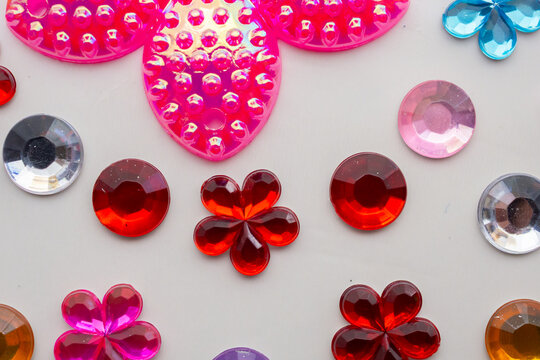 Colorful Flower Shaped Rhinestones and Plastic Gems Craft Accessories on White Background