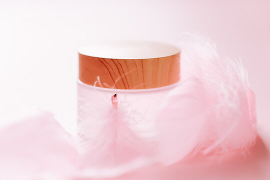 cosmetic container with a wooden lid and feather for advertisements, packaging design, and wellness themes. 