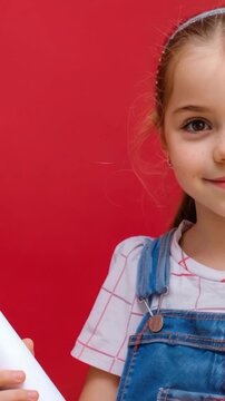 A young child holding a roll of paper, possibly for drawing or art class