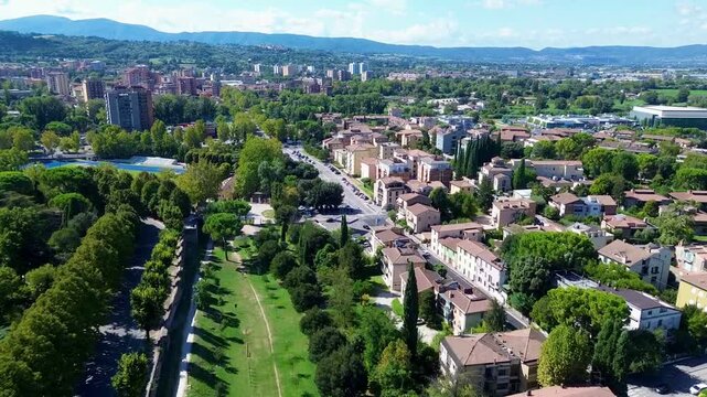 Aerial drone footage of Parco della Passeggiata in Terni, Umbria, Italy, showing lush green trees and peaceful park surroundings on a tranquil late summer morning.