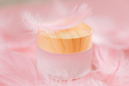 Facial skin care.Cream Jar with Wooden Lid and Feathers for product mockups, branding, natural cosmetics, and wellness concepts. 