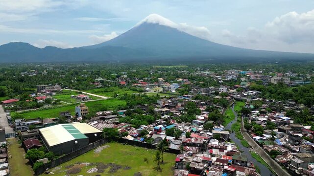 Cinematic drone flight approaching Palanca Warehouse in the San Roque area of Tabaco City, with surrounding buildings, roads and urban landscape visible from above.