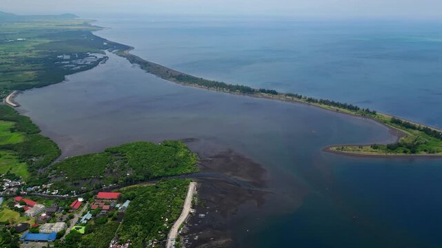 Aerial view of Natunawan Island near Tabaco City, Albay, with Tabaco Port and Mayon Volcano visible in the surrounding landscape. Clear sunny coastal scene showing the island, natural harbor and volca