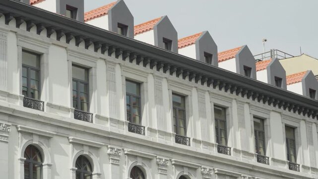 Elegant european architecture featuring rows of windows, balconies, and dormers under a clear sky