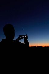 Amateur astronomer with smartphone photographing and observing stars, planets, Moon and other celestial objects. © astrosystem