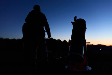 Amateur astronomers observing stars, planets, Moon and other celestial objects with a telescope in nature. © astrosystem