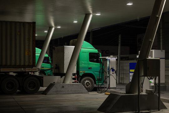 EV charging and semi truck electric vehicle, Electric vehicle semi truck trailer charging station for charge EV battery at night, EV charger semi truck trailer station at night.