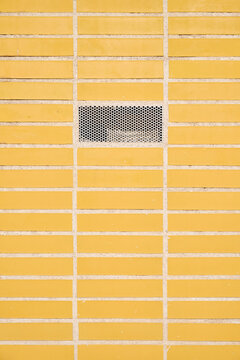 Close-up of a ventilation grille in a tlled wall.