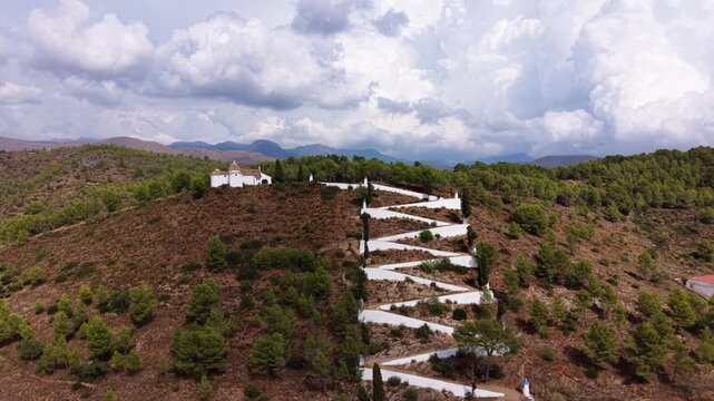Hilltop hermitage of Saint Anthony above Sot de Ferrer, Valencia, Spain, with zigzag white path winding through pine forest between Sierra Calderona and Sierra d'Espada mountains