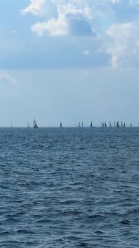 Sailboats move along distant horizon near Istanbul, Turkey. Sailing vessels across open water create a peaceful maritime travel and recreation scene