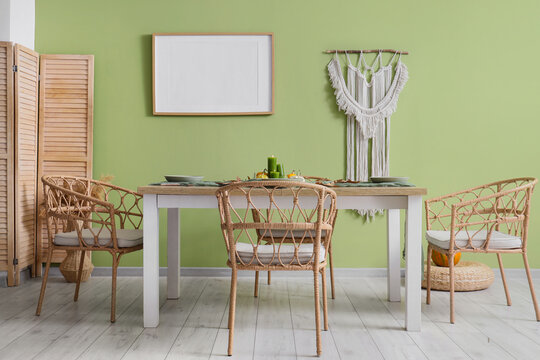 Interior design and home decor, dining room with boho style furniture and empty picture frame on green wall for mockup and lifestyle advertisement