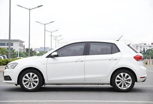 Urban mobility and personal transportation, white hatchback car parked in a modern city parking lot for commuting and travel lifestyle