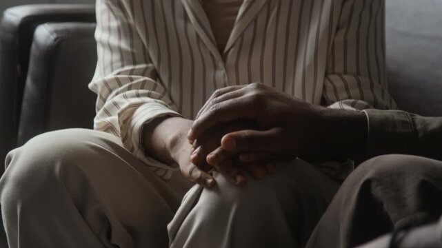 African American man comforting African American woman by holding hands during counseling session. Footage serves mental health support and therapy campaigns
