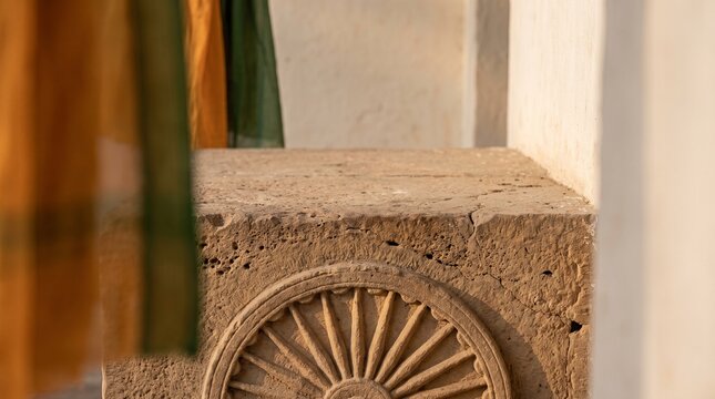Detailed view of a traditional Buddhist Dharmachakra wheel carved in stone on a temple wall