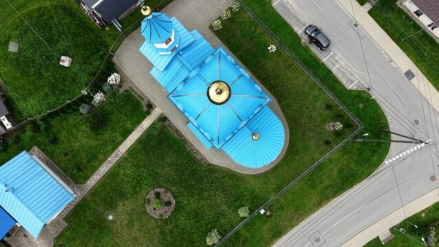 Aerial view of the Russian Orthodox Church of the Nativity of the Most Holy Mother of God with its blue roof and golden dome, surrounded by green lawns in Iecava, Bauskas novads, Latvia.