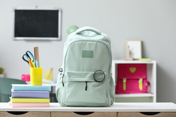 Back to school preparation, student backpack with books and stationery supplies on a desk in a classroom for education and academic learning © Pixel-Shot