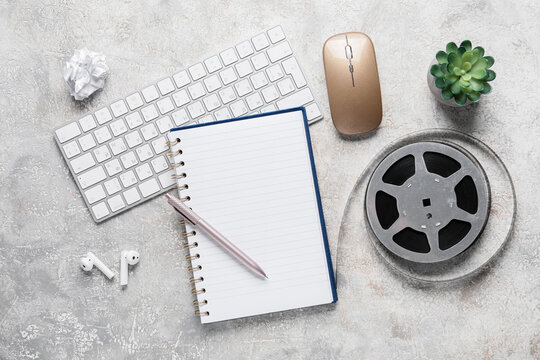 Creative writing and film production planning, notebook with pen and vintage movie reel on office desk for screenwriter or content creator workspace