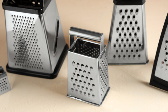 Food preparation and culinary tools, stainless steel kitchen graters for cooking and meal ingredients on a neutral background