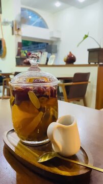 Vertical shot of traditional Vietnamese herbal tea with red dates and ginger served in a glass pot at a cafe